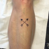 small crisscrossed arrows tattoo