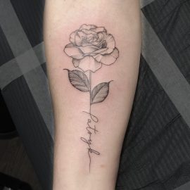 Rose tattoo with script in stem