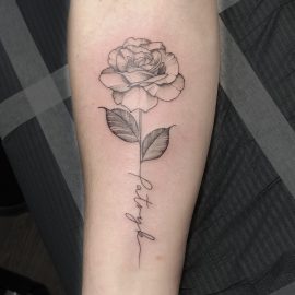 Black and grey rose tattoo with name in stem