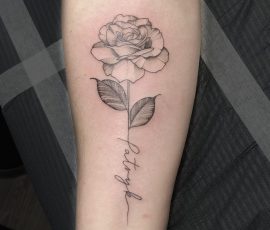 Black and grey rose tattoo with name in stem