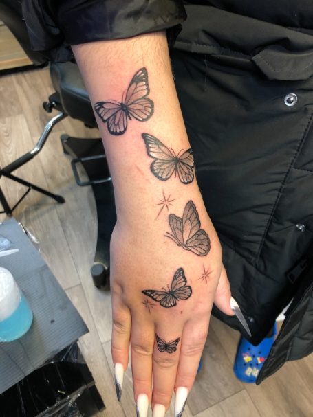 Butterflies on hand tattoo done at Tiger and Rose Tattoo, London